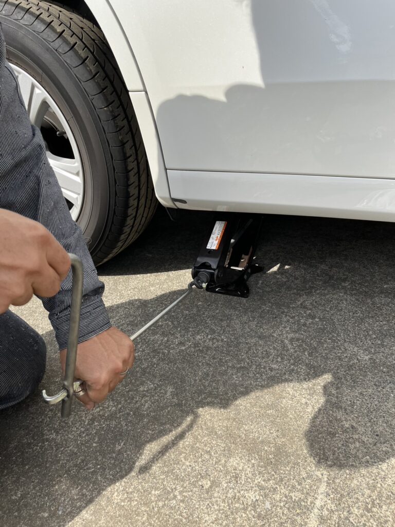 ジャッキのハンドルを回す